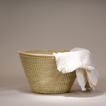 Cette corbeille en paille naturelle s'inspire des nasses à poissons. Elle est confectionnée par le peuple du Lesotho, en Afrique du Sud. Cette corbeille est l'accessoire parfait pour organiser vos objets du quotidien. Avec son fond plat et sa forme évasée, elle devient une corbeille très pratique, idéale pour ranger des plaids, des journaux, des jouets, et bien plus encore. L'artisanat traditionnel le plus répandu au Lesotho est celui réalisé à partir d'herbes. Grâce à l'abondance de diverses herbes dans les hautes terres montagneuses, les artisans disposent toujours de matières premières. Les femmes basotho, à travers le pays, démontrent un grand talent dans l'art du tissage de paniers. Ces paniers, fabriqués à partir de robustes herbes locales, sont soigneusement enroulés et maintenus par de fines cordelettes de coton. Matériau – Palme Dimensions approx. : Ø 48 cm x H 27 cm